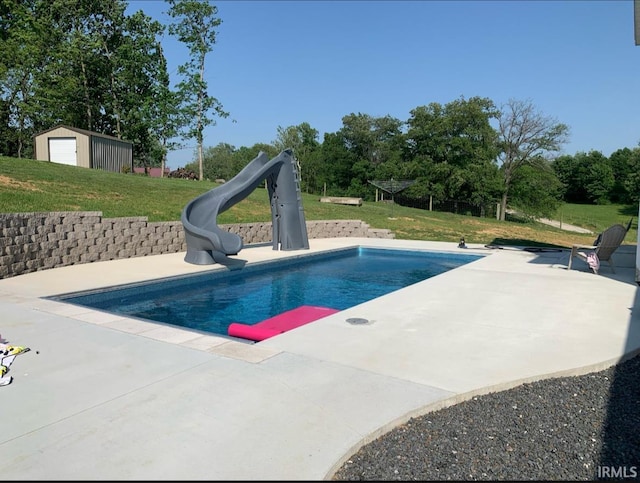 view of pool featuring a yard, a patio, and a water slide