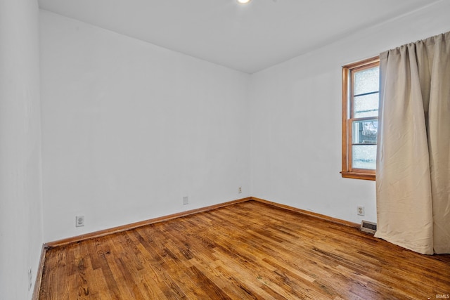 unfurnished room with hardwood / wood-style flooring