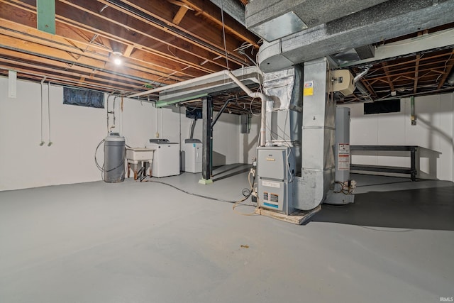 basement featuring washer and dryer, sink, and water heater