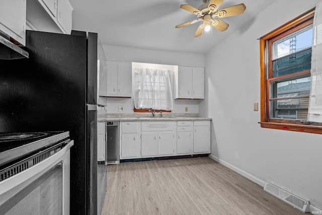 kitchen featuring white cabinetry, ceiling fan, sink, stainless steel appliances, and light hardwood / wood-style flooring