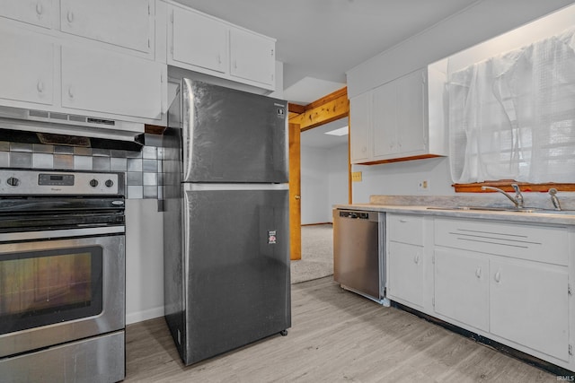 kitchen featuring sink, white cabinets, stainless steel appliances, and range hood