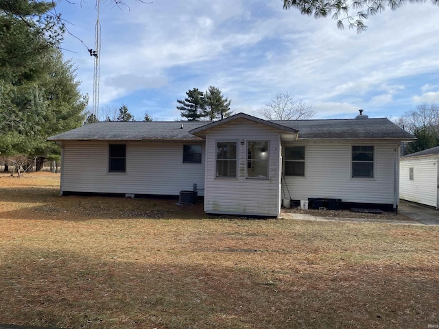 rear view of property with a yard and central AC