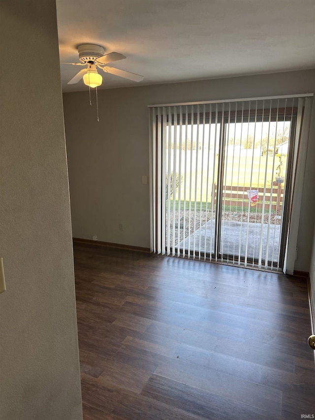 unfurnished room featuring a wealth of natural light, ceiling fan, and dark wood-type flooring