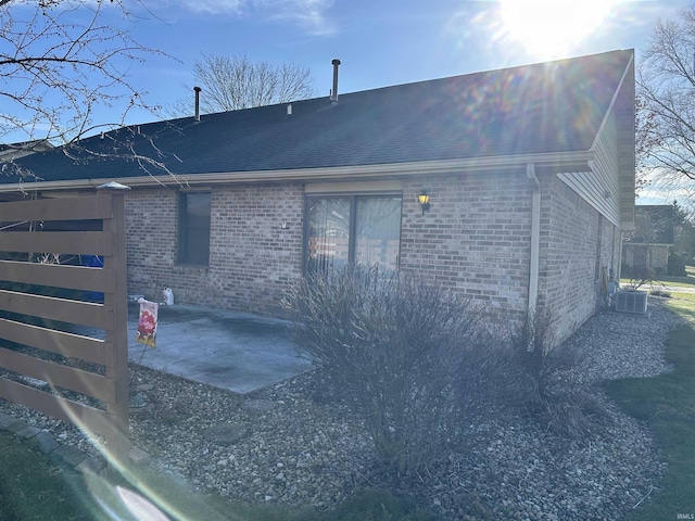 view of side of home with central air condition unit and a patio area