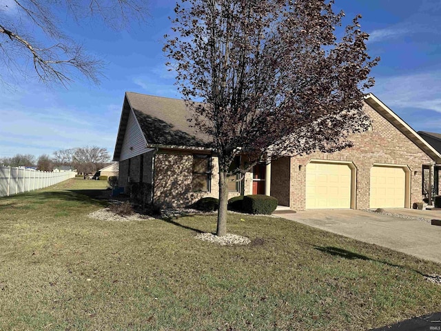 view of property hidden behind natural elements with a garage and a front lawn