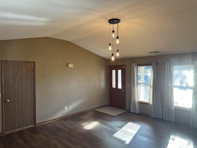 entrance foyer with a chandelier, hardwood / wood-style floors, a healthy amount of sunlight, and vaulted ceiling