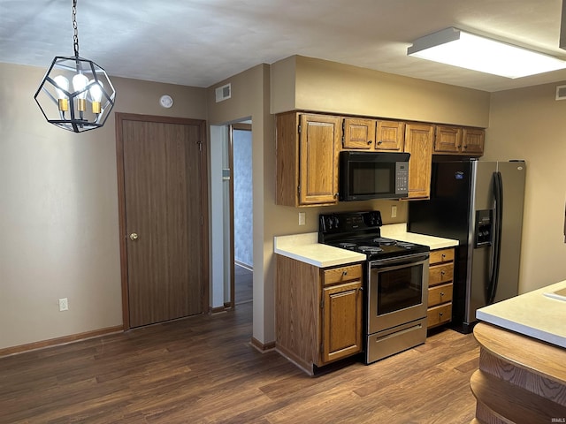 kitchen with dark wood-type flooring, pendant lighting, a notable chandelier, and appliances with stainless steel finishes