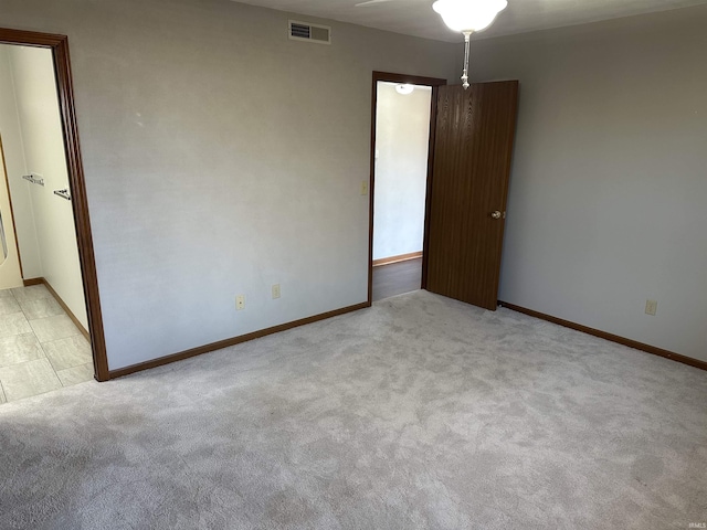 unfurnished room featuring light carpet