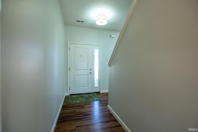 doorway to outside with dark hardwood / wood-style flooring and a textured ceiling