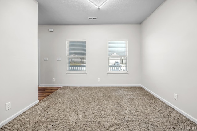 carpeted spare room featuring a textured ceiling