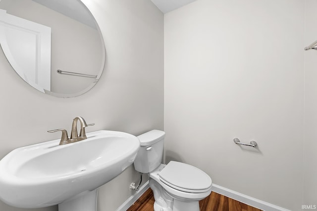 bathroom featuring hardwood / wood-style flooring, toilet, and sink