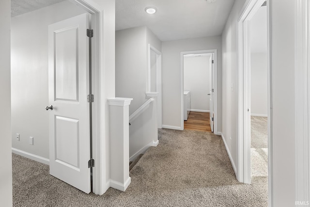 corridor with carpet and a textured ceiling