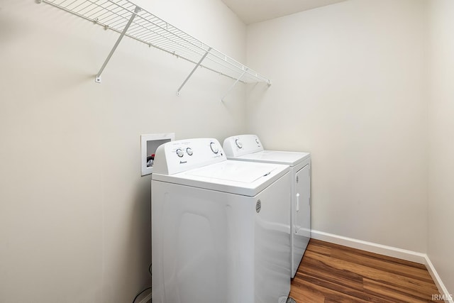 clothes washing area featuring dark hardwood / wood-style floors and independent washer and dryer