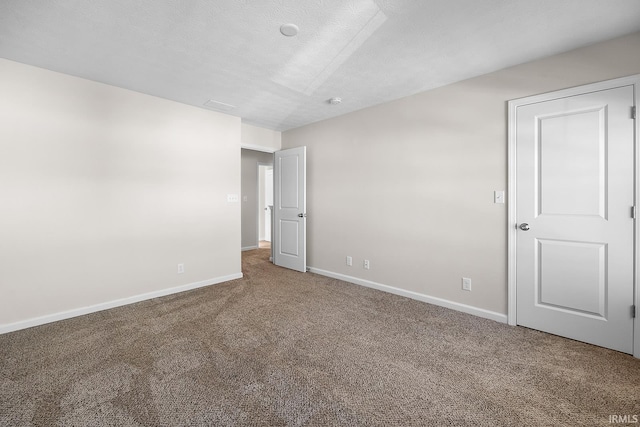 empty room featuring carpet and a textured ceiling