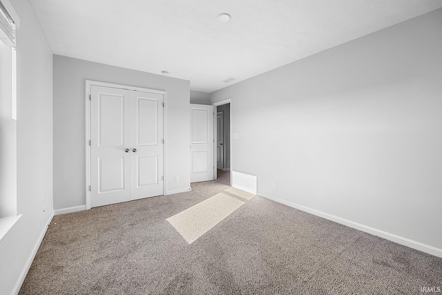 unfurnished bedroom with a closet and carpet floors