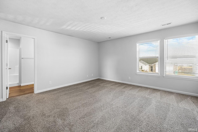 carpeted empty room with a textured ceiling