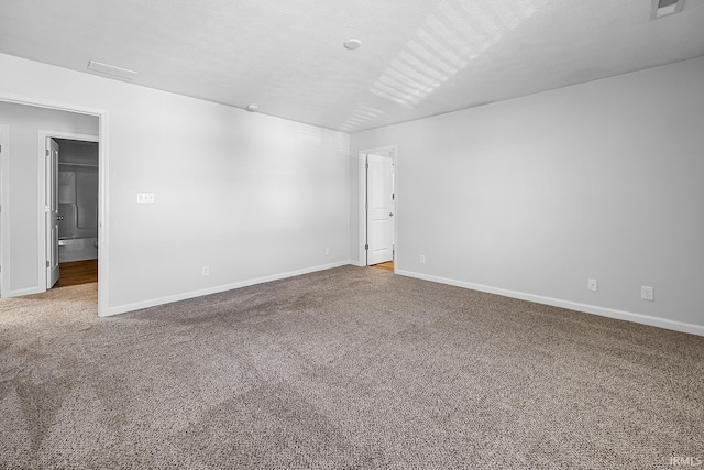 spare room featuring carpet flooring and a textured ceiling