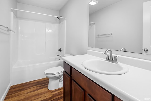 full bathroom featuring washtub / shower combination, toilet, wood-type flooring, and vanity