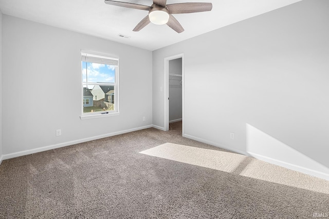 empty room with ceiling fan and carpet floors