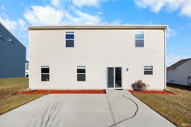 rear view of house featuring a lawn and a patio