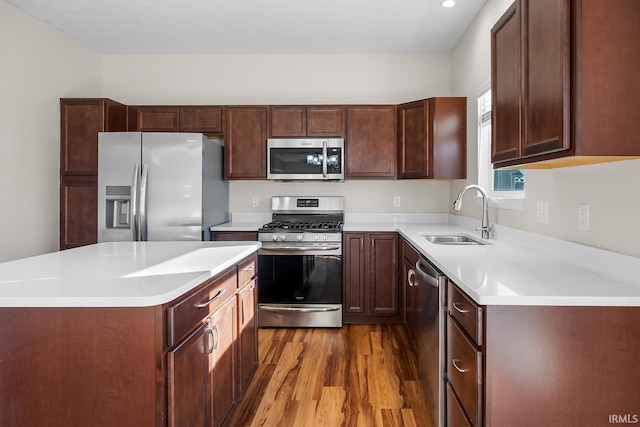 kitchen featuring hardwood / wood-style floors, a center island, sink, and appliances with stainless steel finishes