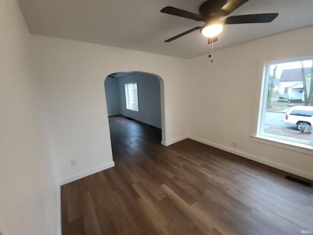 unfurnished room with ceiling fan and dark wood-type flooring