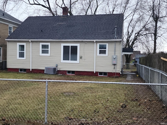 rear view of property with a yard and central air condition unit