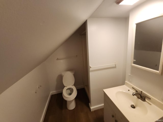 bathroom featuring vanity, toilet, lofted ceiling, and wood-type flooring