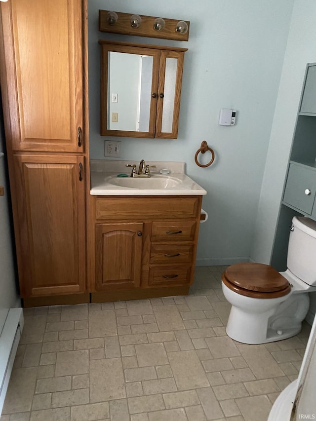 bathroom with vanity, toilet, and baseboard heating