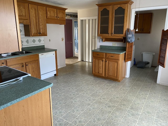 kitchen featuring dishwasher, sink, and backsplash