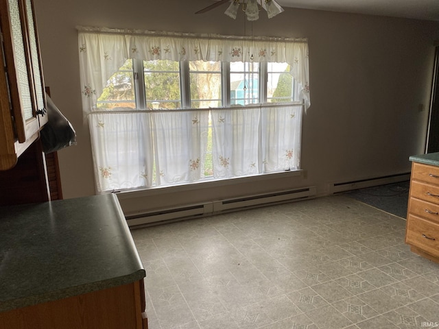 interior space featuring baseboard heating, a healthy amount of sunlight, and ceiling fan