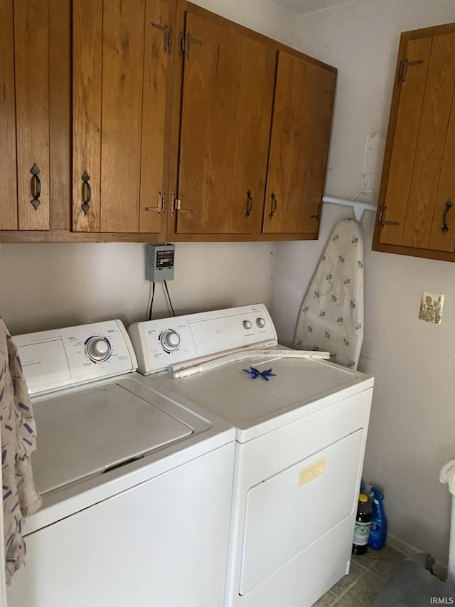 washroom featuring washer and dryer, tile patterned flooring, and cabinets