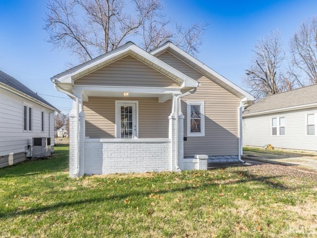 bungalow-style home with central AC, a front lawn, and covered porch