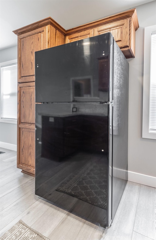 interior details featuring hardwood / wood-style floors and black fridge