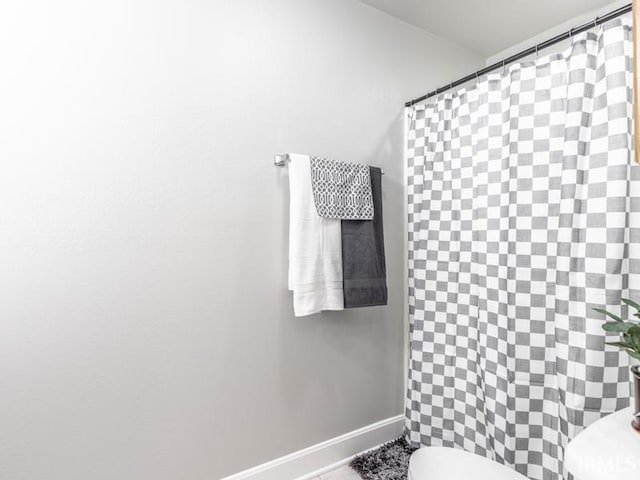 bathroom with curtained shower and toilet