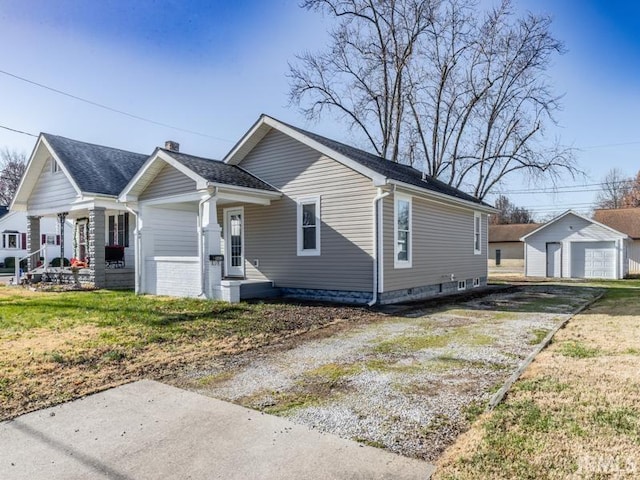 bungalow-style house with an outbuilding, a front lawn, and a garage