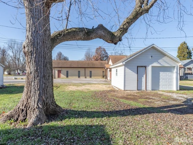 exterior space featuring an outbuilding, a front lawn, and a garage