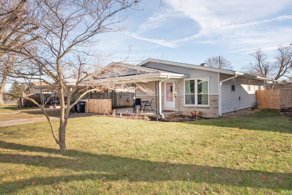 view of front of home featuring a front lawn and a patio