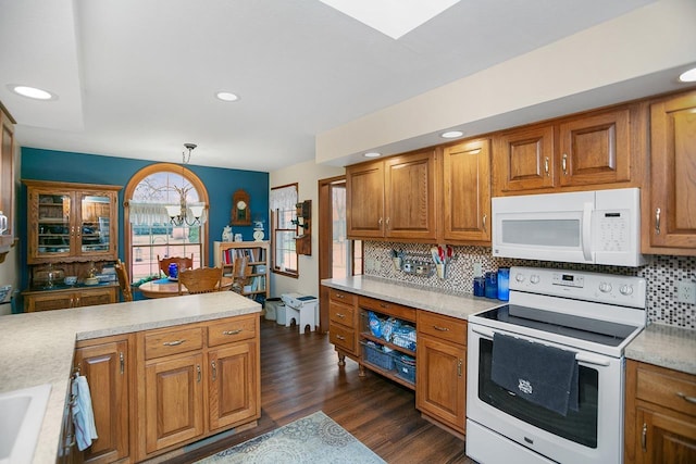 kitchen with decorative backsplash, white appliances, dark wood-type flooring, decorative light fixtures, and a notable chandelier