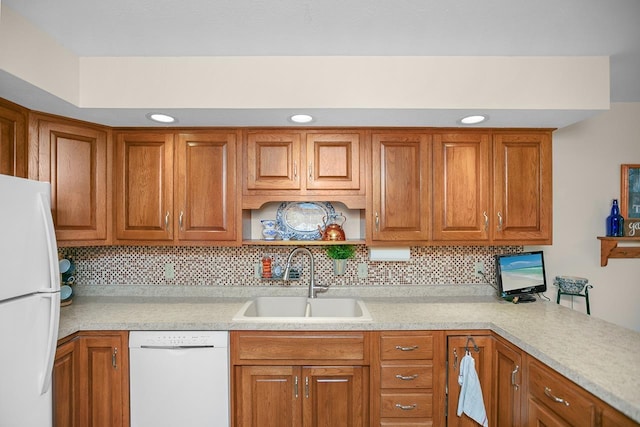 kitchen featuring white appliances, tasteful backsplash, and sink