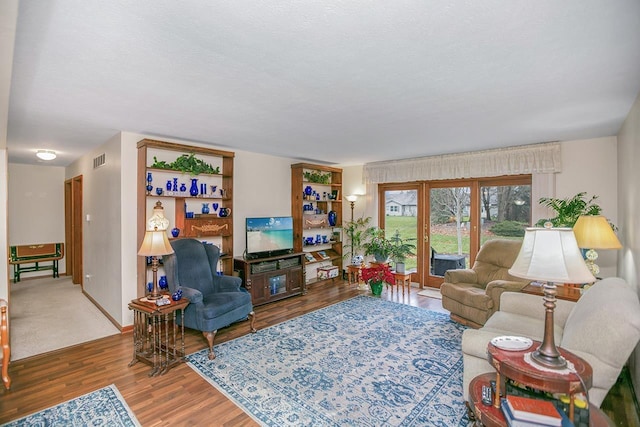 living room with hardwood / wood-style flooring and a textured ceiling