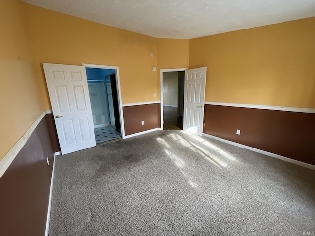 unfurnished bedroom with carpet flooring and a walk in closet