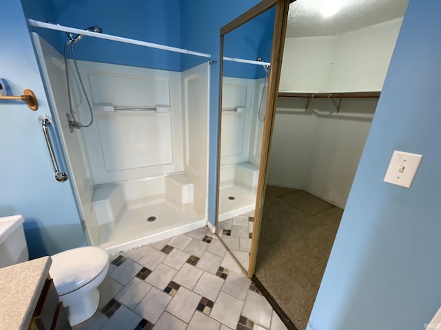 bathroom featuring a shower, vanity, and toilet