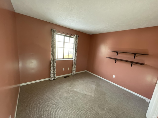 unfurnished room featuring carpet and a textured ceiling