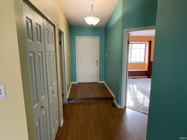 doorway featuring a textured ceiling and hardwood / wood-style flooring