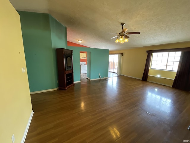 empty room with ceiling fan, dark hardwood / wood-style flooring, lofted ceiling, and a textured ceiling