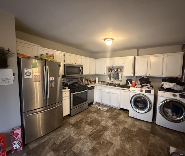 kitchen with washing machine and dryer, white cabinetry, and stainless steel appliances