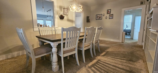 carpeted dining room featuring an inviting chandelier