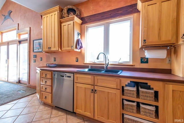 kitchen featuring stainless steel dishwasher, light tile patterned floors, sink, and light brown cabinetry