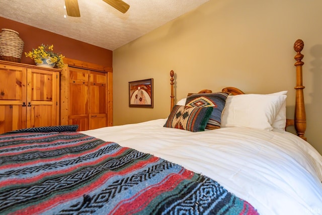 bedroom with ceiling fan, vaulted ceiling, a textured ceiling, and a closet